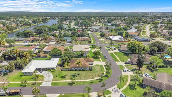 an aerial view of residential houses with outdoor space and parking