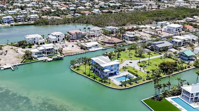 an aerial view of a house with garden space and a car park in front of it