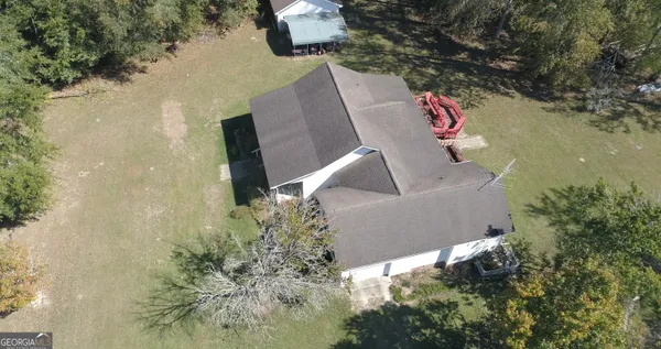 a aerial view of a house with a yard potted plants and a bench