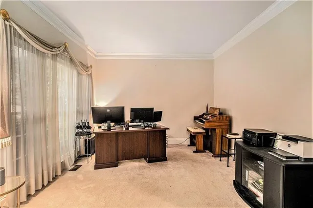 a view of a workspace with furniture and a window