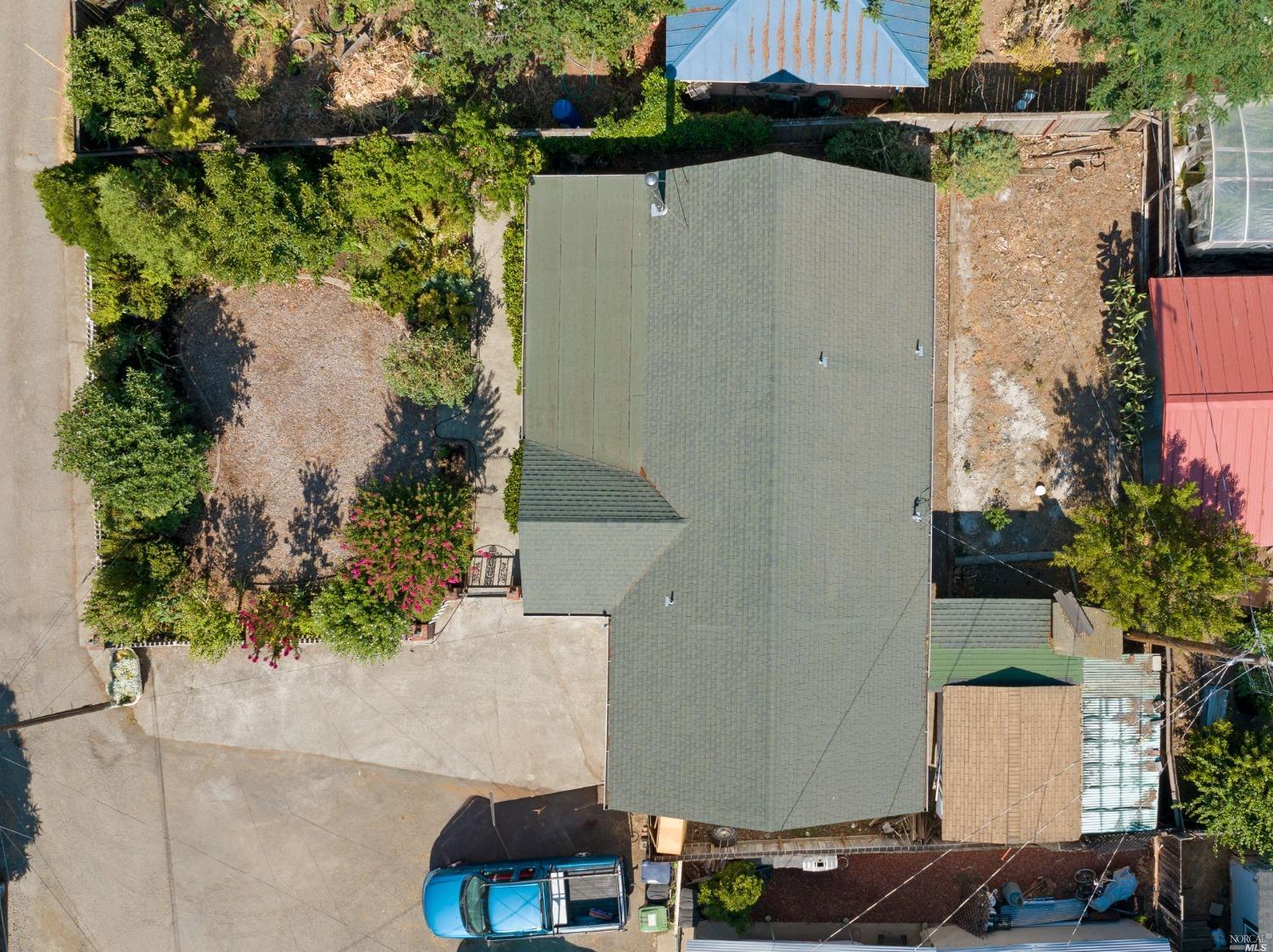 an aerial view of a house with a yard and trees