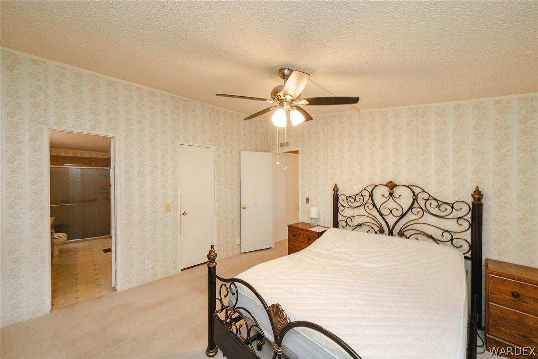 3003 Hualapai Mountain Road Kingman, AZ 86401 - Photo 18 of 49 a bedroom with a bed and a chandelier