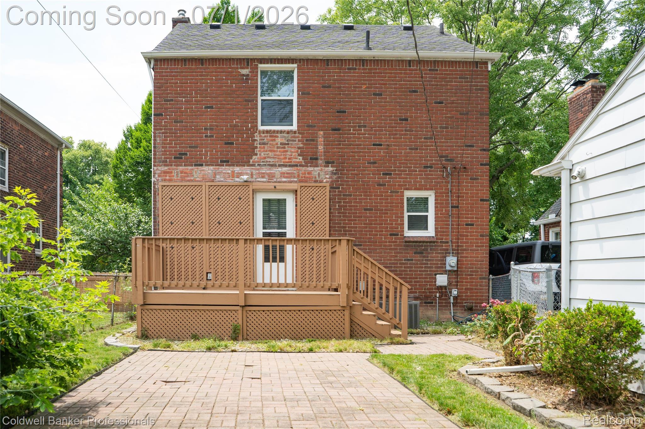 1168 Vernier Road Grosse Pointe, MI 48236 - Photo 5 of 32 Brick exterior featuring a rear deck with lattice skirting, wood railings, and stairs leading to a paver patio