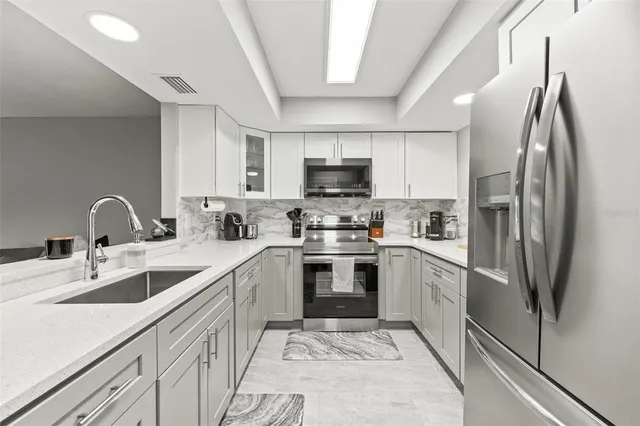 a kitchen with stainless steel appliances granite countertop a refrigerator sink and stove