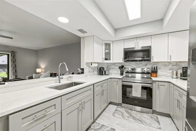 a kitchen with kitchen island a sink stainless steel appliances and white cabinets