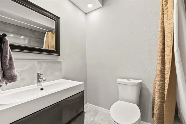 a bathroom with a toilet a sink and a mirror