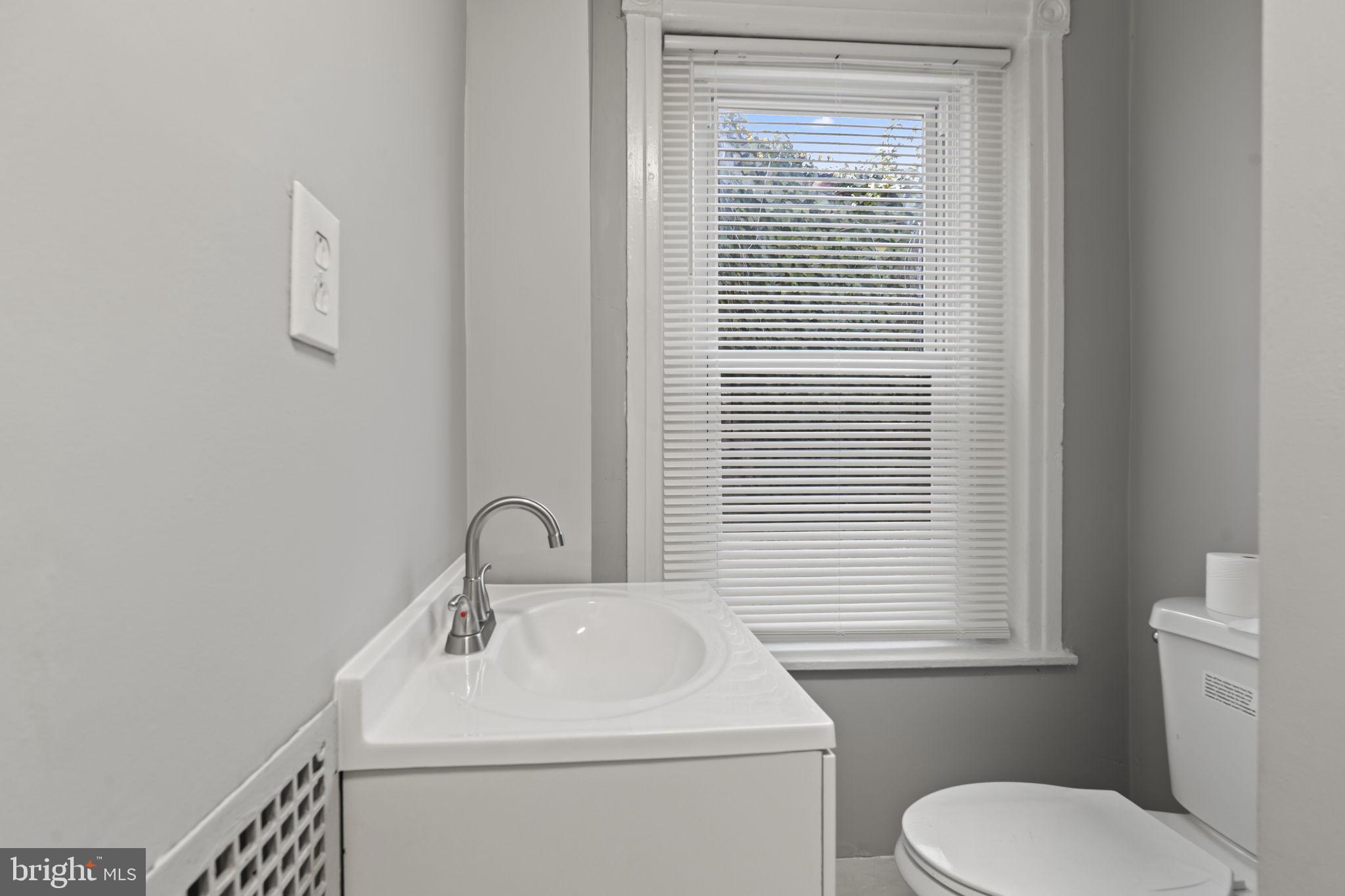 2314 West 3rd Street Chester, PA 19013 - Photo 23 of 32 a bathroom with a sink a toilet and a window
