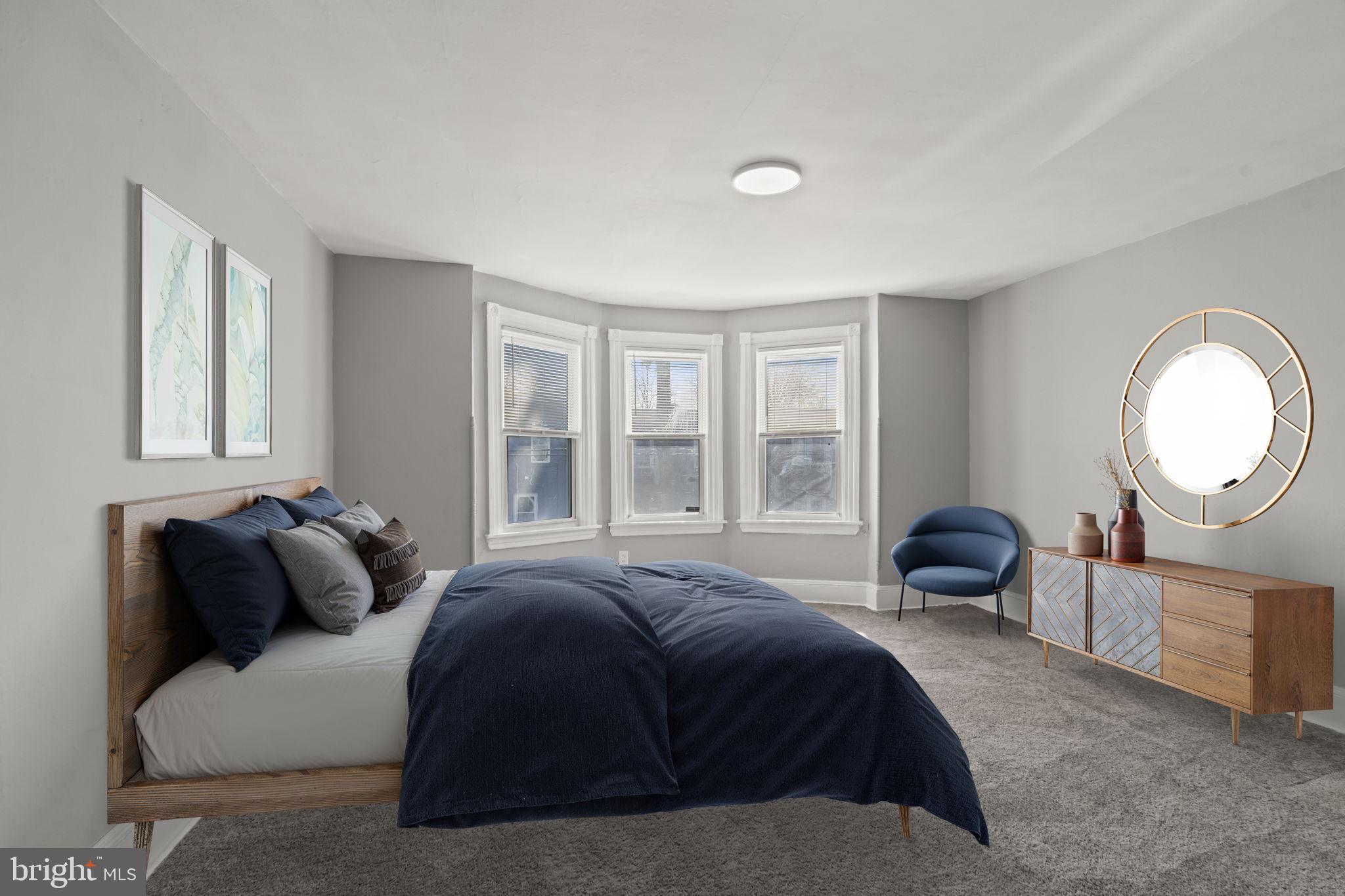 2314 West 3rd Street Chester, PA 19013 - Photo 27 of 32 a spacious bedroom with a bed a mirror and a large window