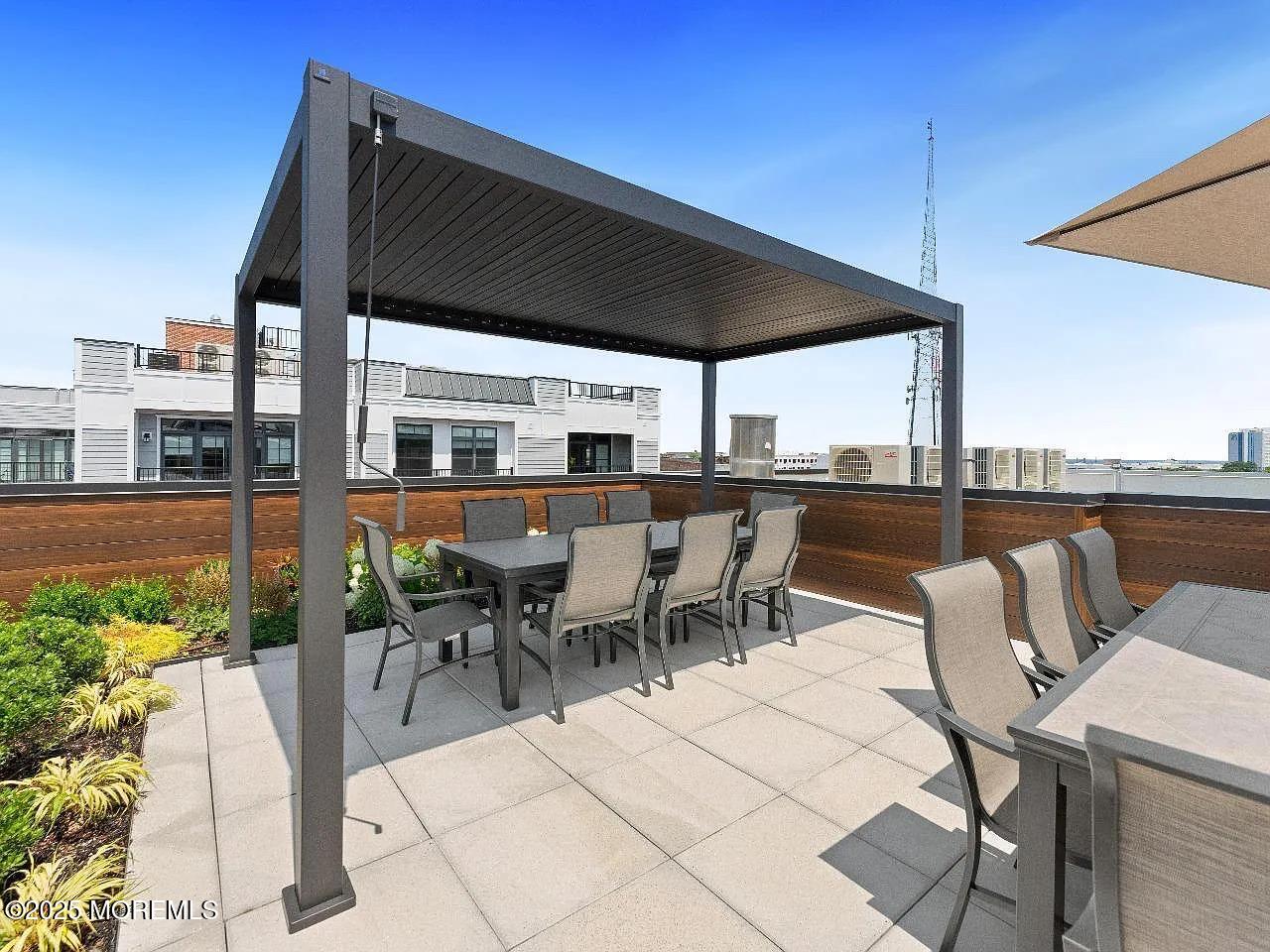 27 3rd Avenue, Unit 304 Long Branch, NJ 07740 - Photo 22 of 28 a view of a patio with a table and chairs under an umbrella