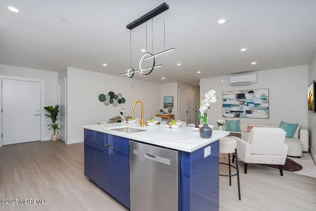 a living room with furniture and a dining table with kitchen view