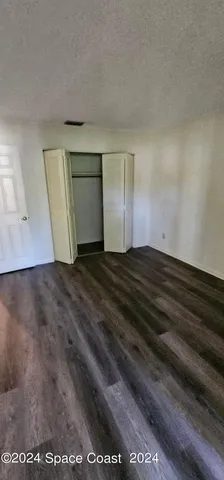 a view of an empty room with closet and a window