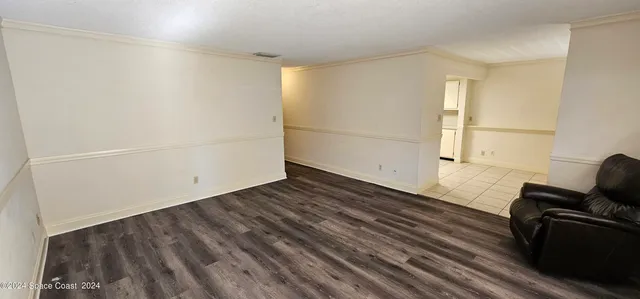 a view of a room with wooden floor and furniture