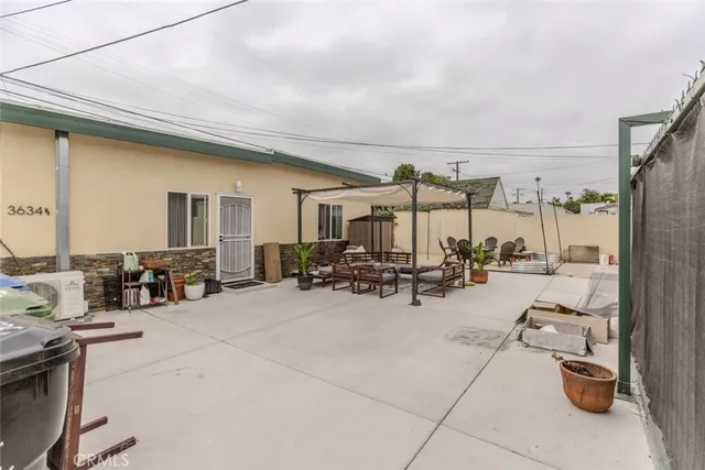 a view of a patio with dining table and chairs with potted plants