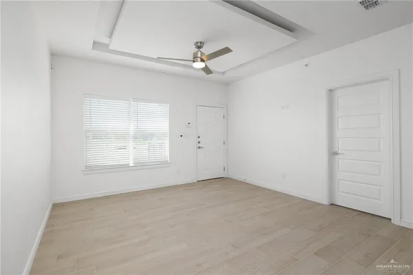 an empty room with a ceiling fan and a window