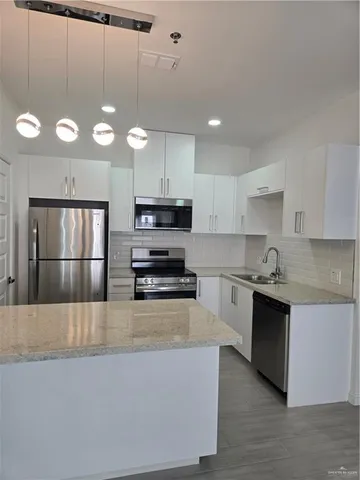 a kitchen with stainless steel appliances and refrigerator