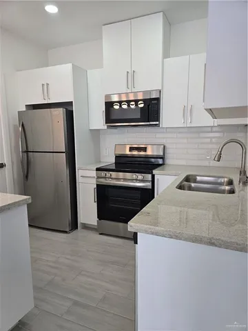 a kitchen with a refrigerator sink and stove