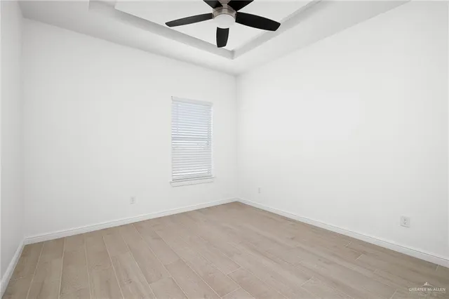 an empty room with a window and a ceiling fan