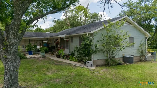 a view of a house with backyard sitting area and garden