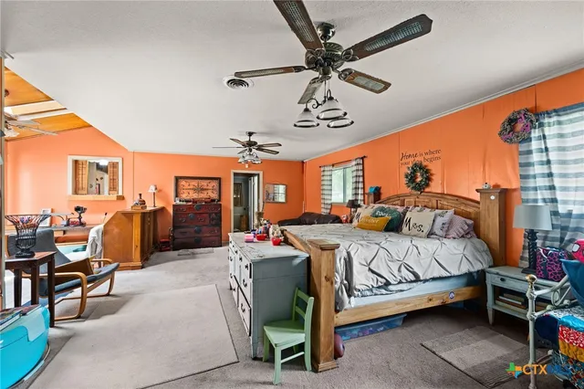 a bedroom with a bed a chandelier and couches