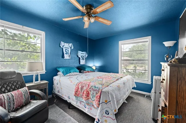 a bedroom with a bed couch and a window