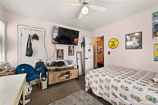 a bedroom with a bed a flat screen tv and dresser