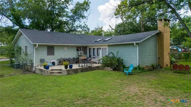 a view of a house with backyard sitting area and garden