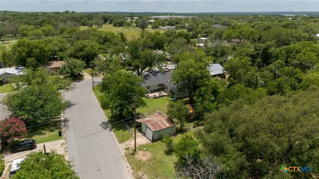 an aerial view of a house with a yard and lake view