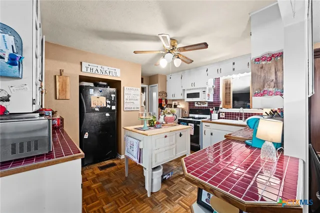 a kitchen with stainless steel appliances kitchen island granite countertop a refrigerator stove and sink