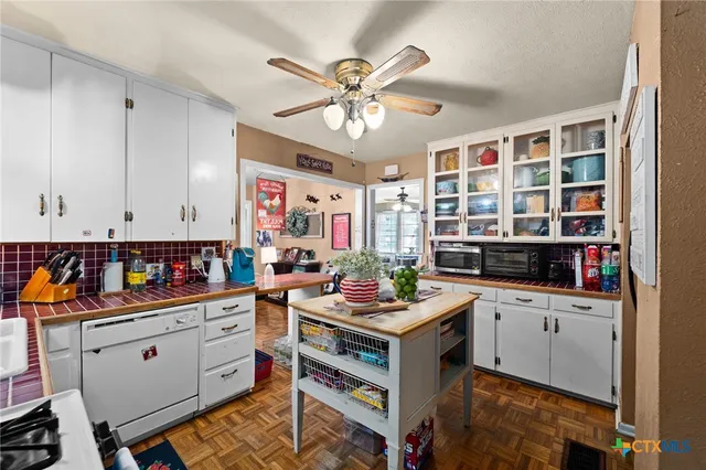 a work place with a large window and cabinets