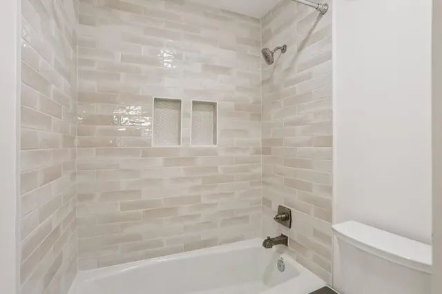 a bathroom with a granite countertop sink mirror and a bathtub