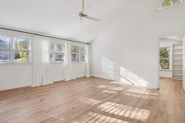 a view of a livingroom with wooden floor and kitchen space