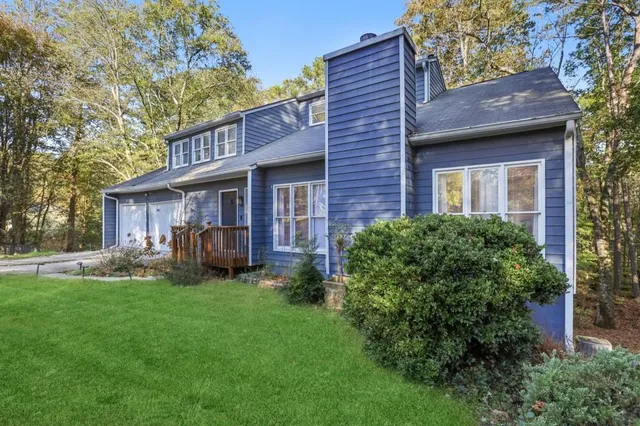 a view of a house with a yard and sitting area