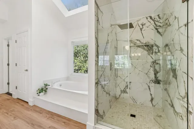 a white bath tub sitting in a bathroom next to a window