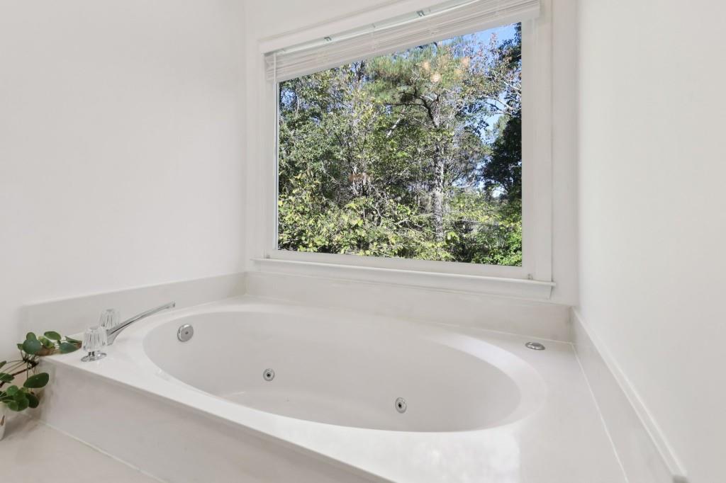 10630 Timberstone Road Alpharetta, GA 30022 - Photo 35 of 42 a white bath tub sitting in a bathroom next to a window