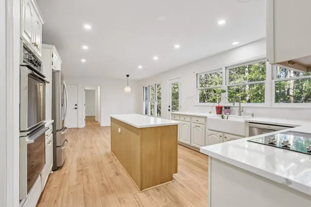 a large kitchen with stainless steel appliances a lot of counter space and a large window