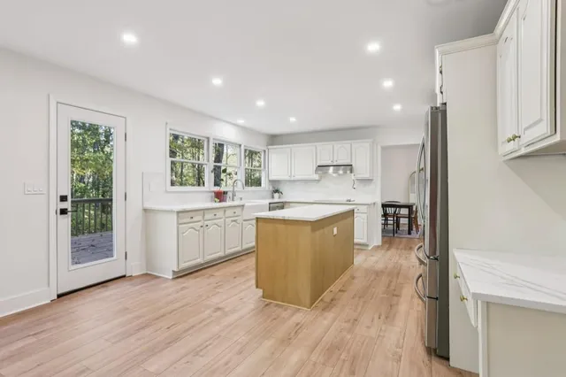 a large kitchen with stainless steel appliances granite countertop a large center island and a wooden floors