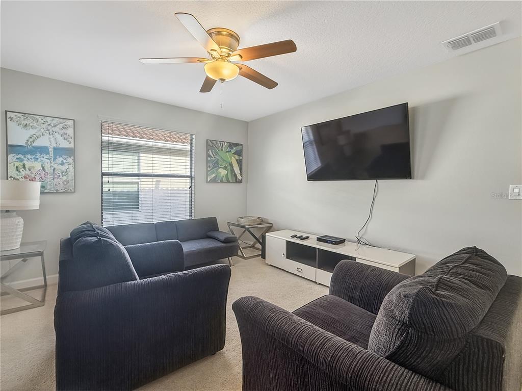 2942 Buccaneer Palm Road Kissimmee, FL 34747 - Photo 12 of 39 a living room with furniture and a flat screen tv