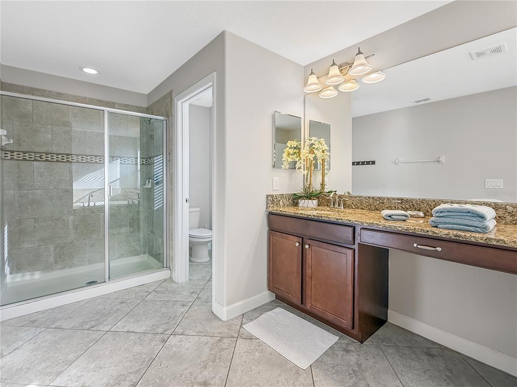 2942 Buccaneer Palm Road Kissimmee, FL 34747 - Photo 15 of 39 a spacious bathroom with a granite countertop sink mirror and shower