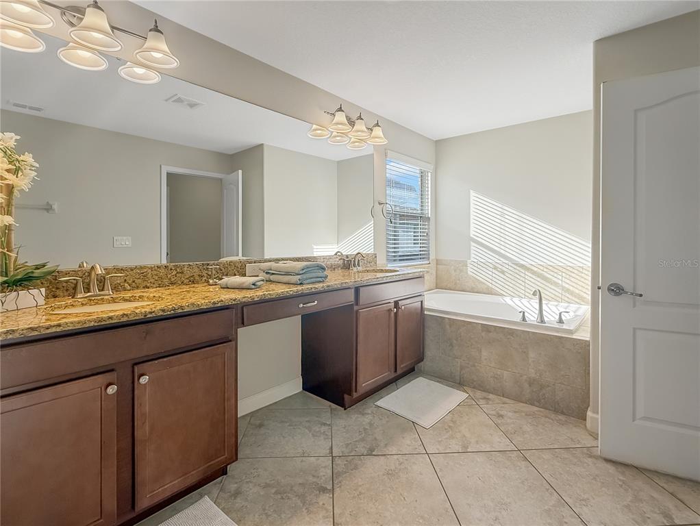 2942 Buccaneer Palm Road Kissimmee, FL 34747 - Photo 16 of 39 a large bathroom with a granite countertop sink and a large mirror