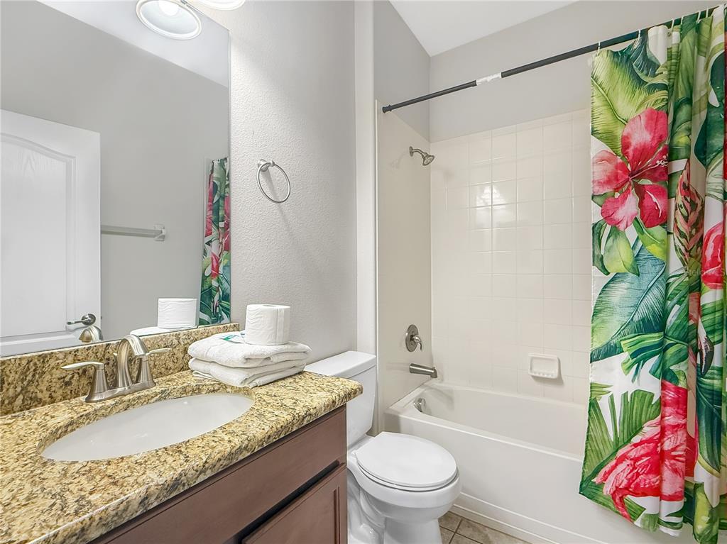 2942 Buccaneer Palm Road Kissimmee, FL 34747 - Photo 24 of 39 a bathroom with a granite countertop bathtub sink vanity mirror and toilet