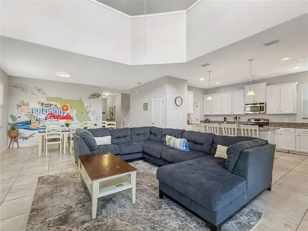 a living room with furniture and a dining table with kitchen view