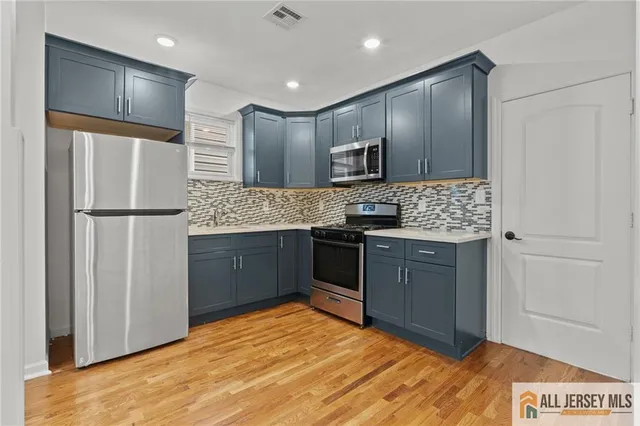 a kitchen with stainless steel appliances granite countertop a refrigerator a sink and a stove