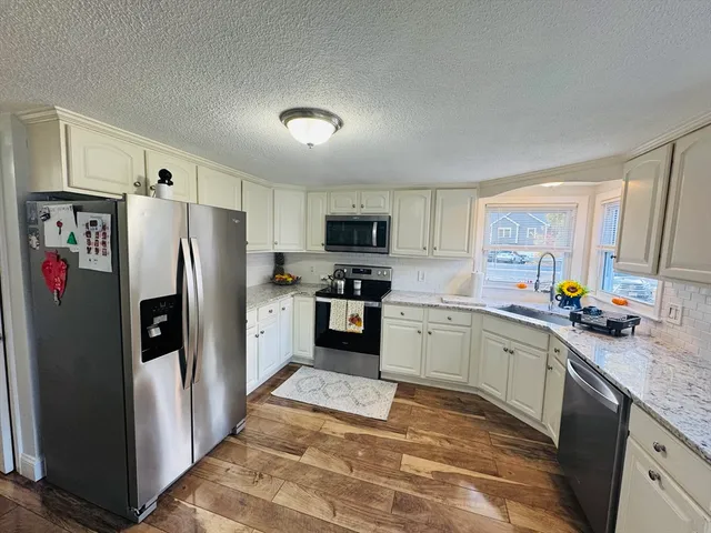 a kitchen with a refrigerator a microwave a sink and cabinets