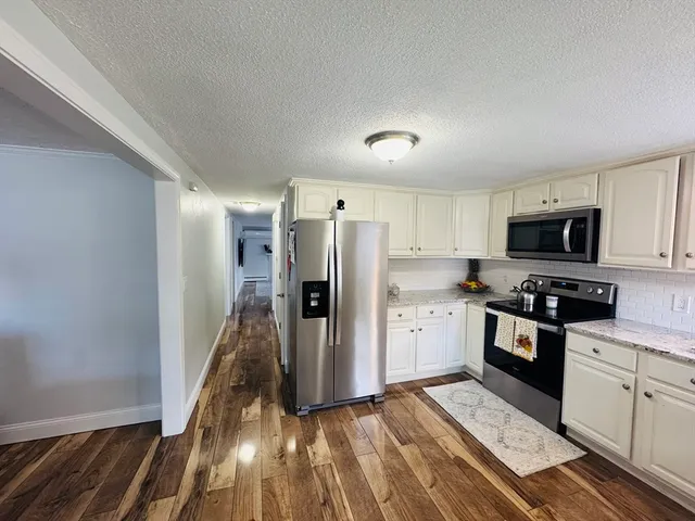 a kitchen with stainless steel appliances a refrigerator and a stove top oven