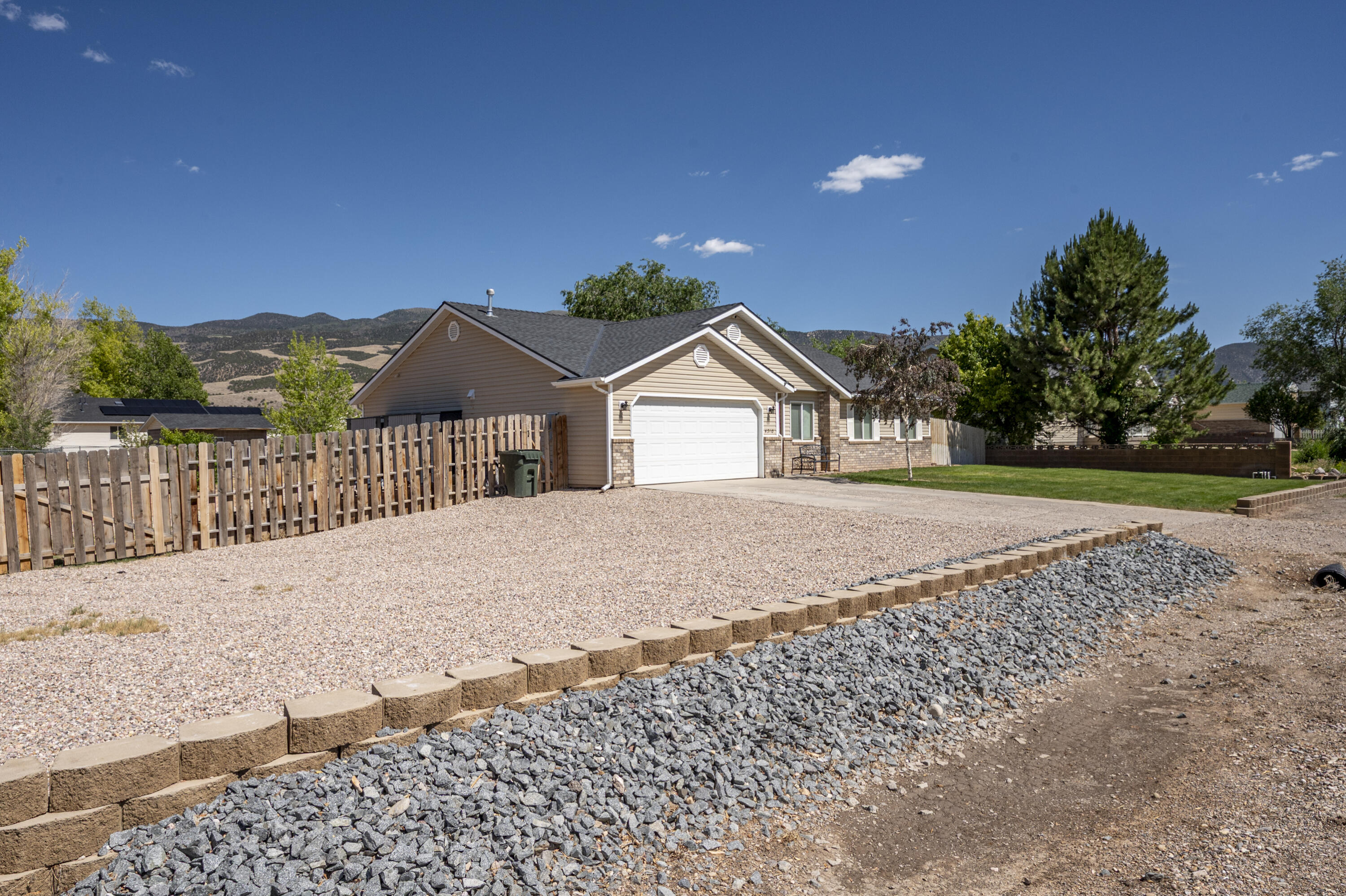 4510 North Half Mile Road Cedar City, UT 84721 - Photo 3 of 48 A graveled area at the front of the home offers ample off-street parking in addition to the driveway and attached garage.