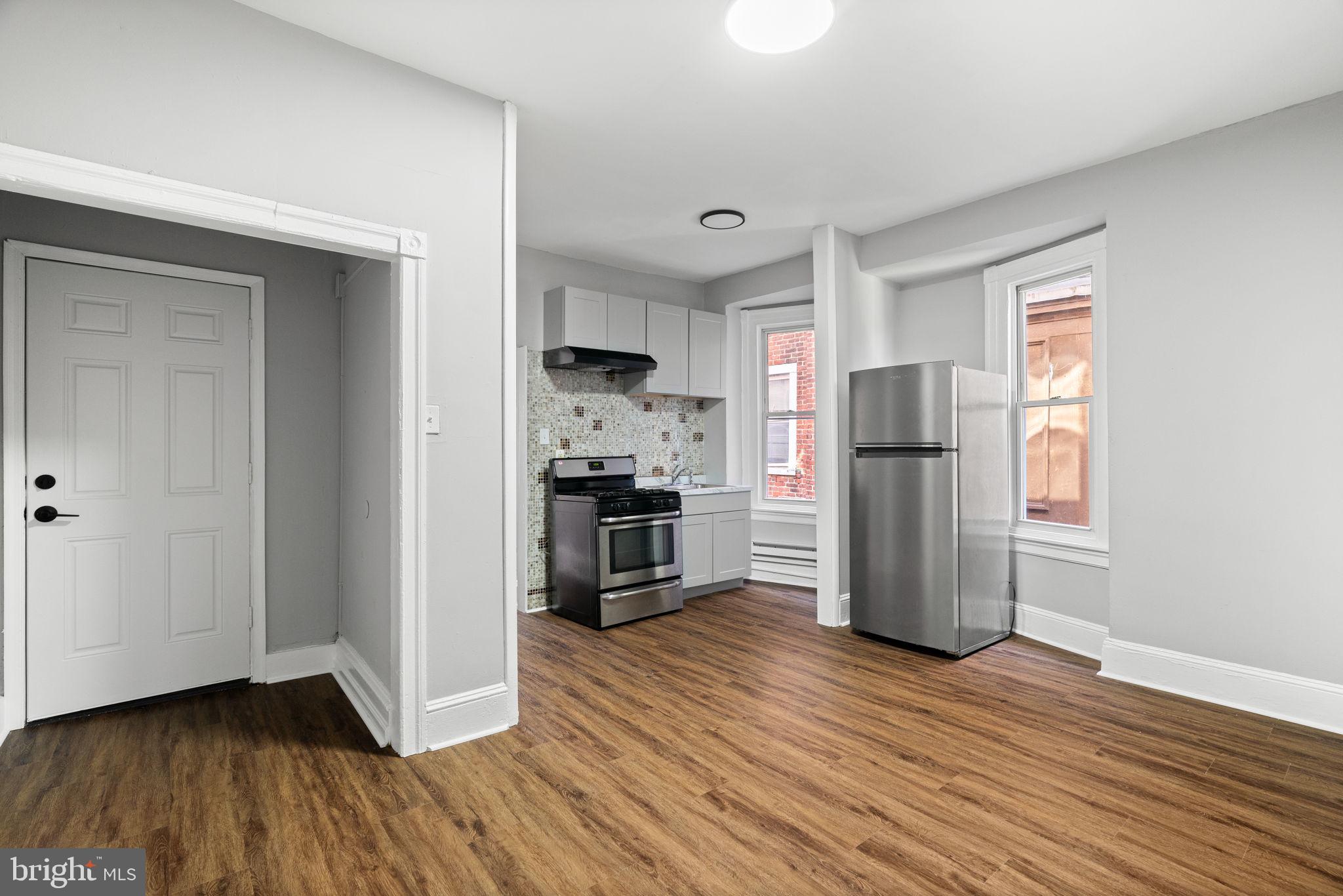 147 Manheim Street Philadelphia, PA 19144 - Photo 17 of 37 a kitchen with a refrigerator a stove and a wooden floor