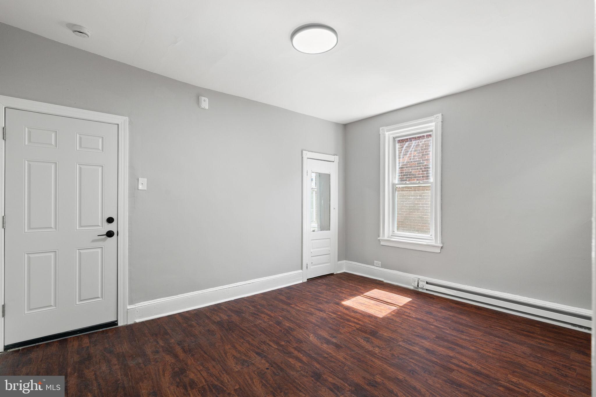 147 Manheim Street Philadelphia, PA 19144 - Photo 31 of 37 an empty room with wooden floor and windows