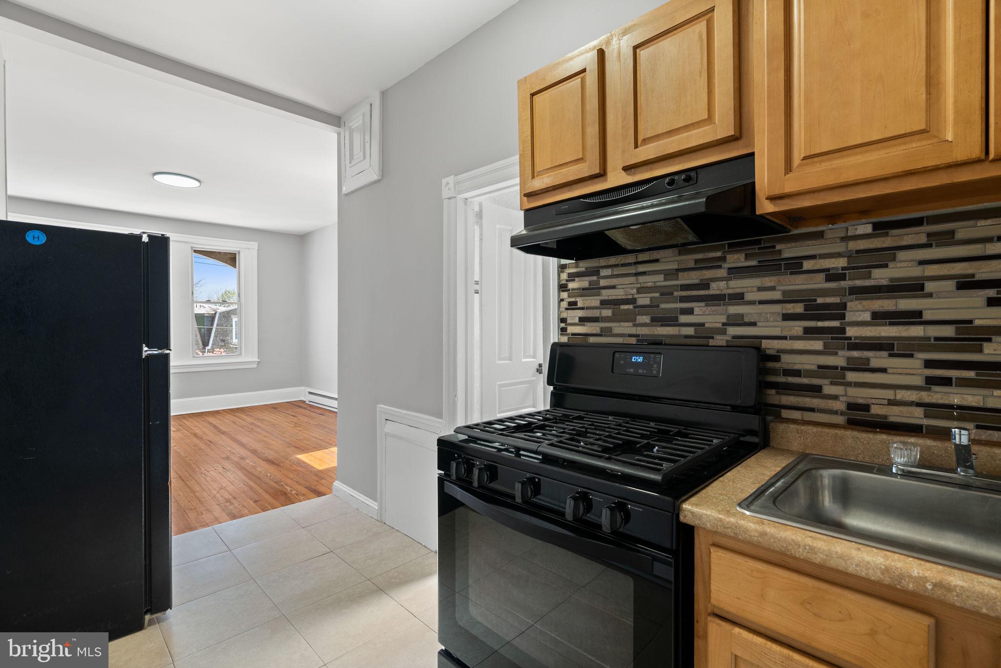147 Manheim Street Philadelphia, PA 19144 - Photo 32 of 37 a kitchen with granite countertop cabinets and a stove top oven