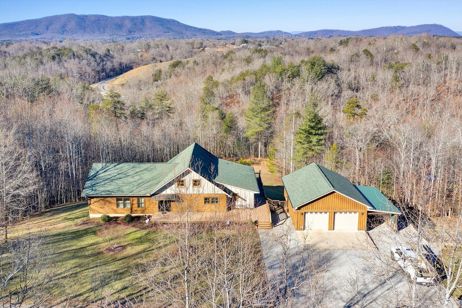a view of a house with a yard and a large tree