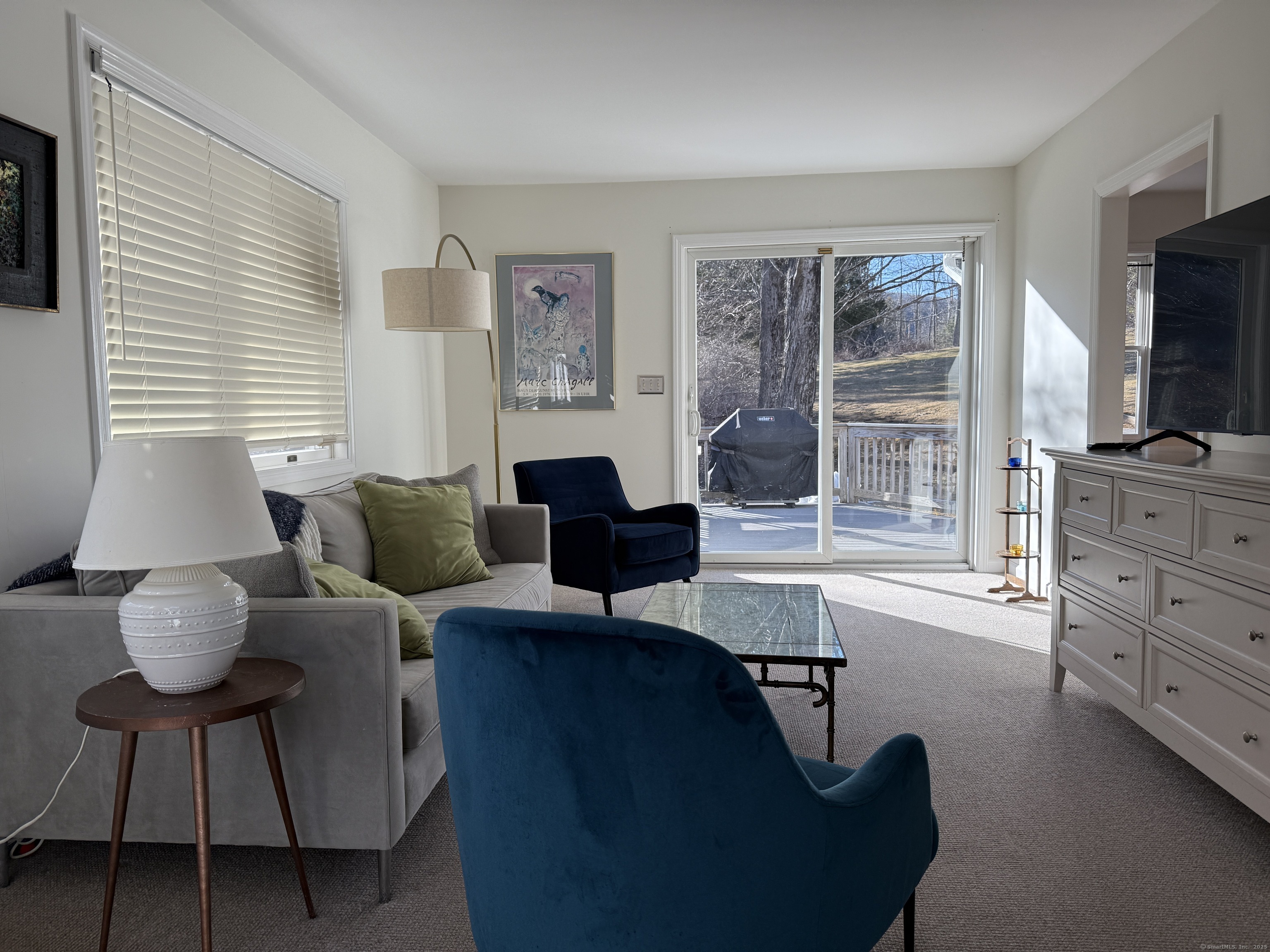 a living room with furniture a flat screen tv and a window